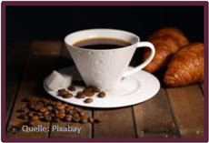 Bild mit Kaffeetasse und Kaffebohnen, im Hintergrund zwei Hörnchen